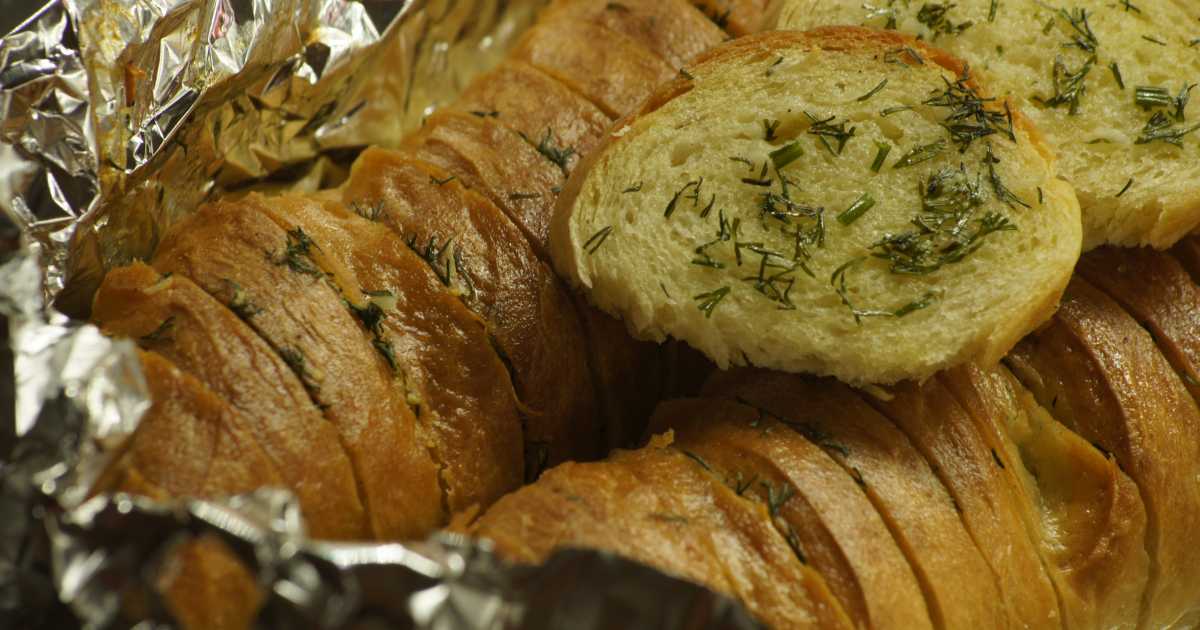 Рецепт багета в духовке с фото. Чесночный багет в духовке. Чесночный хлеб. Хлеб с чесноком. Багет с чесноком и зеленью в духовке.